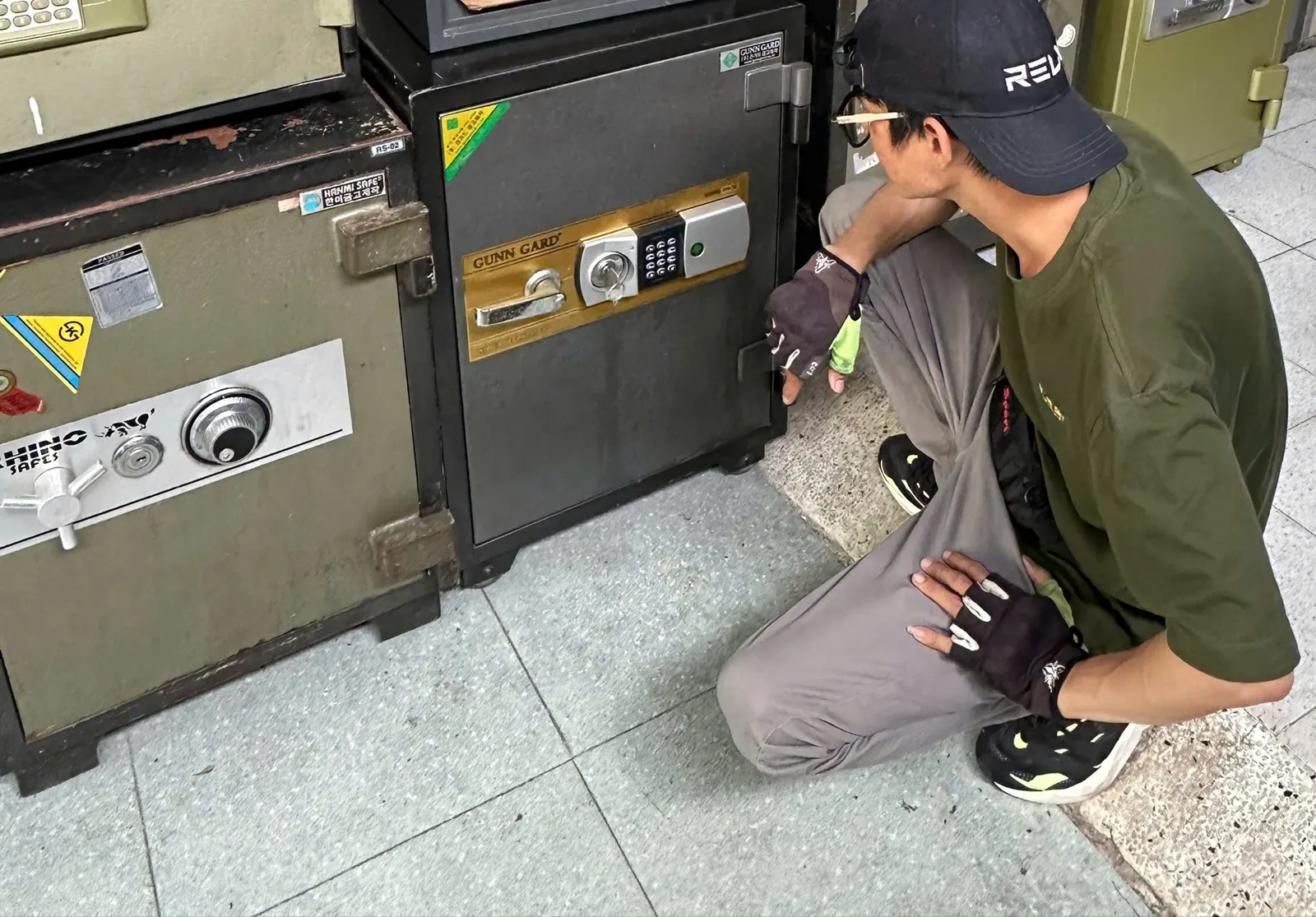 Thợ kiểm tra hai két sắt: một két khóa cơ, một két điện tử