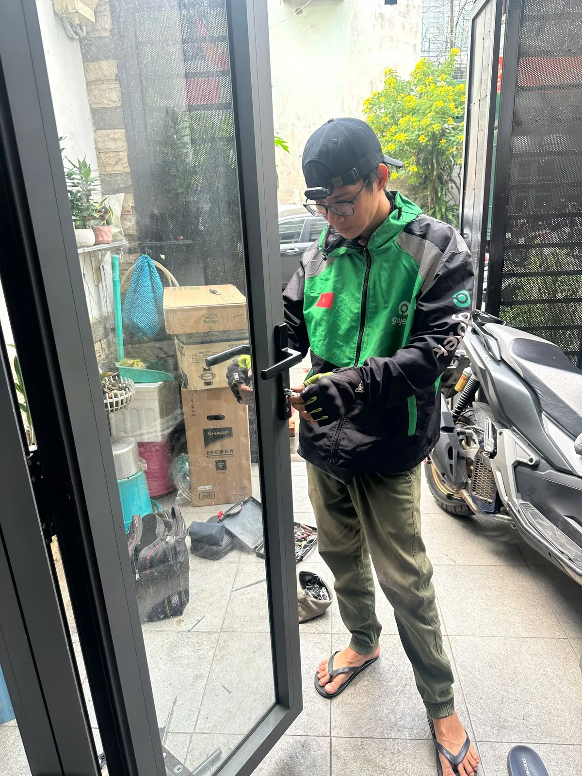 Thợ đứng ở cửa nhôm kính nhà ống
