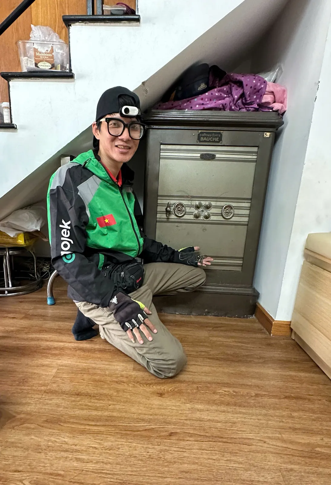 Thợ ngồi bên két sắt đặt dưới gầm cầu thang