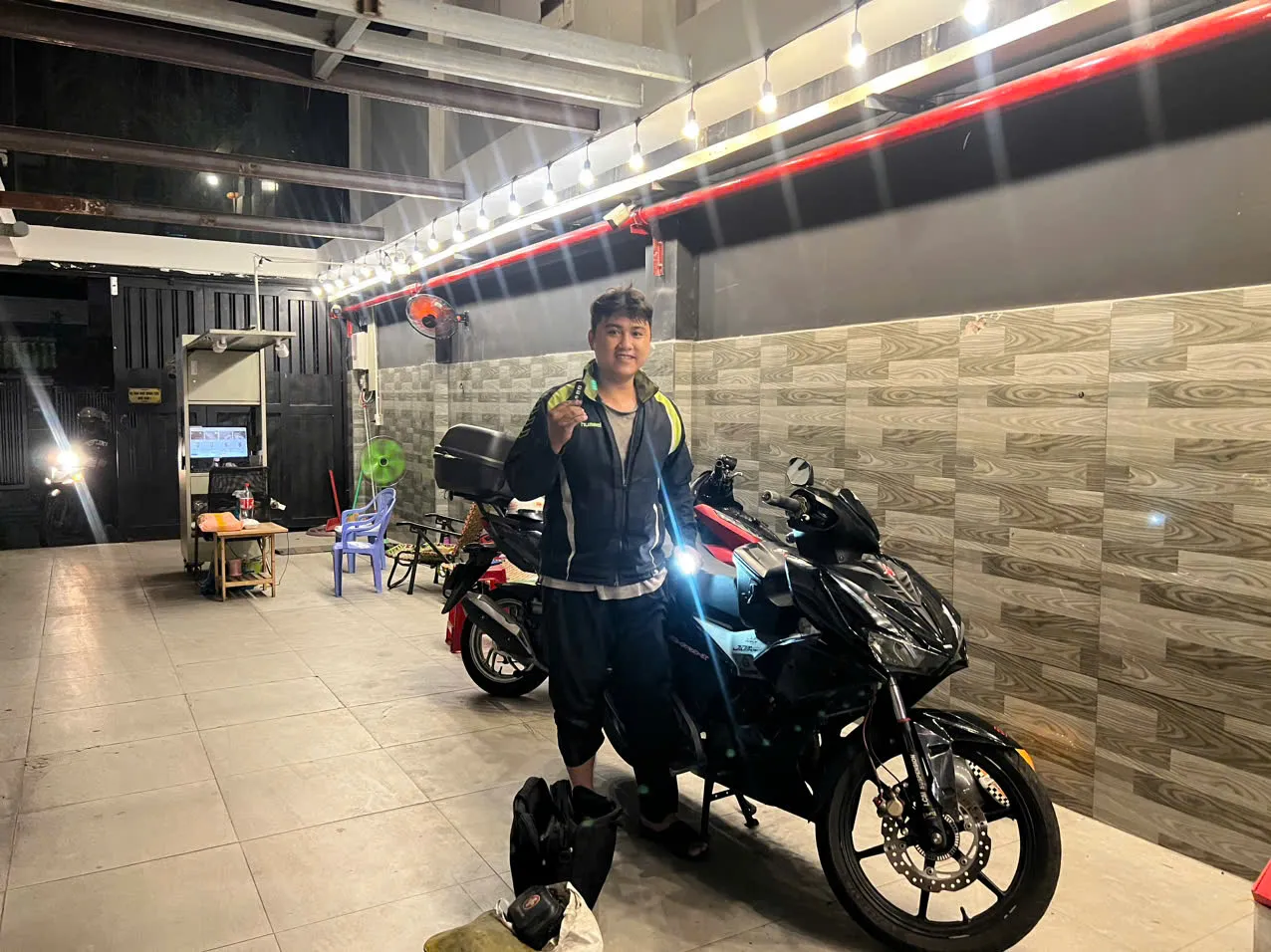 Thợ đứng bên xe côn tay trong nhà giữ xe