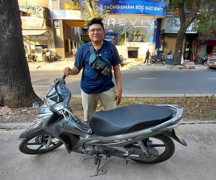 Thợ đứng bên xe số Honda trên phố