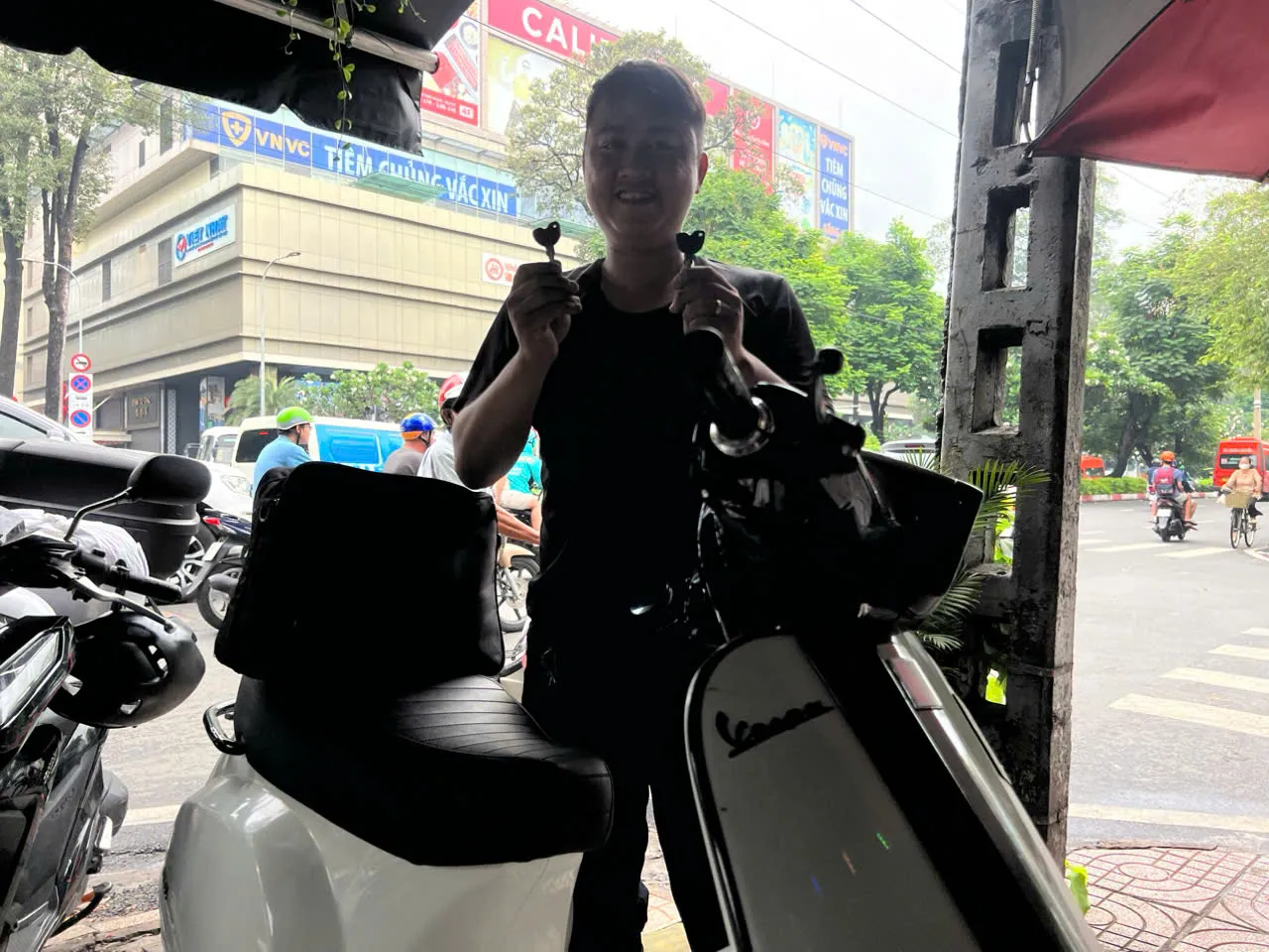 Thợ đứng bên xe Vespa sau khi làm khóa