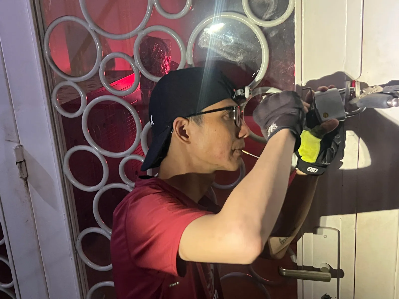 Thợ đeo đèn đội đầu mở khóa cửa sắt