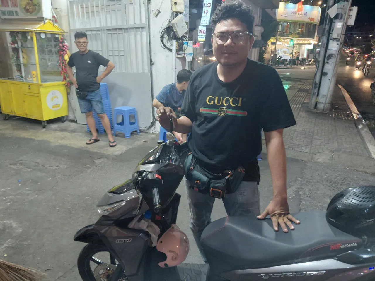 Thợ khóa bên xe tay ga Honda trên phố buổi tối