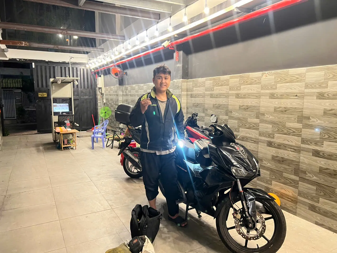 Thợ khóa cầm chìa vừa làm bên xe côn tay buổi tối