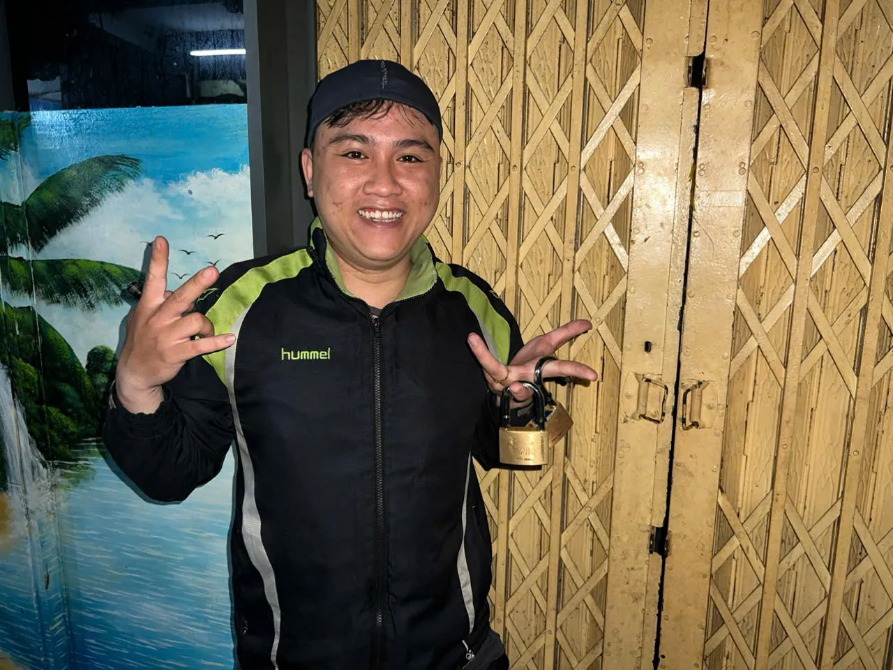 Thợ cầm ổ khóa móc vừa xử lý trước cửa sắt kéo