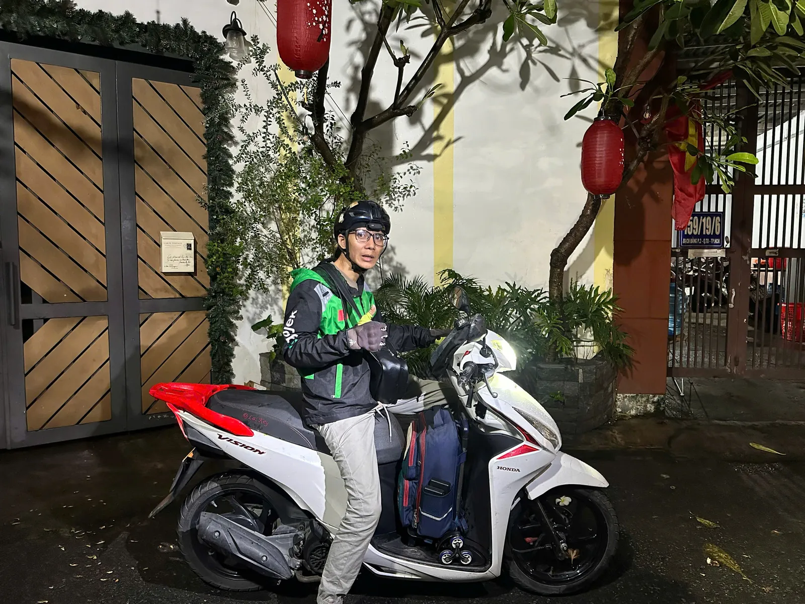 Thợ khóa chạy xe máy tới trước cổng nhà khách buổi tối