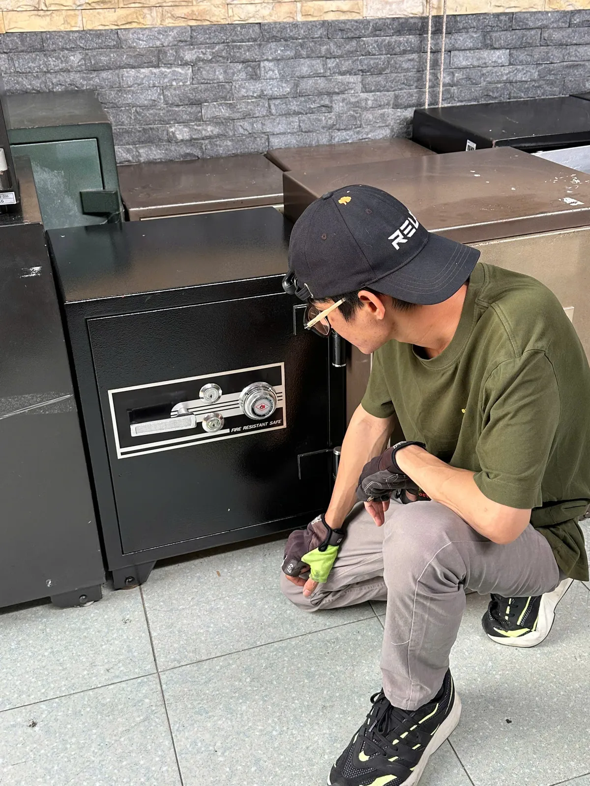 Thợ ngồi bên két sắt đen khóa cơ tại nhà khách