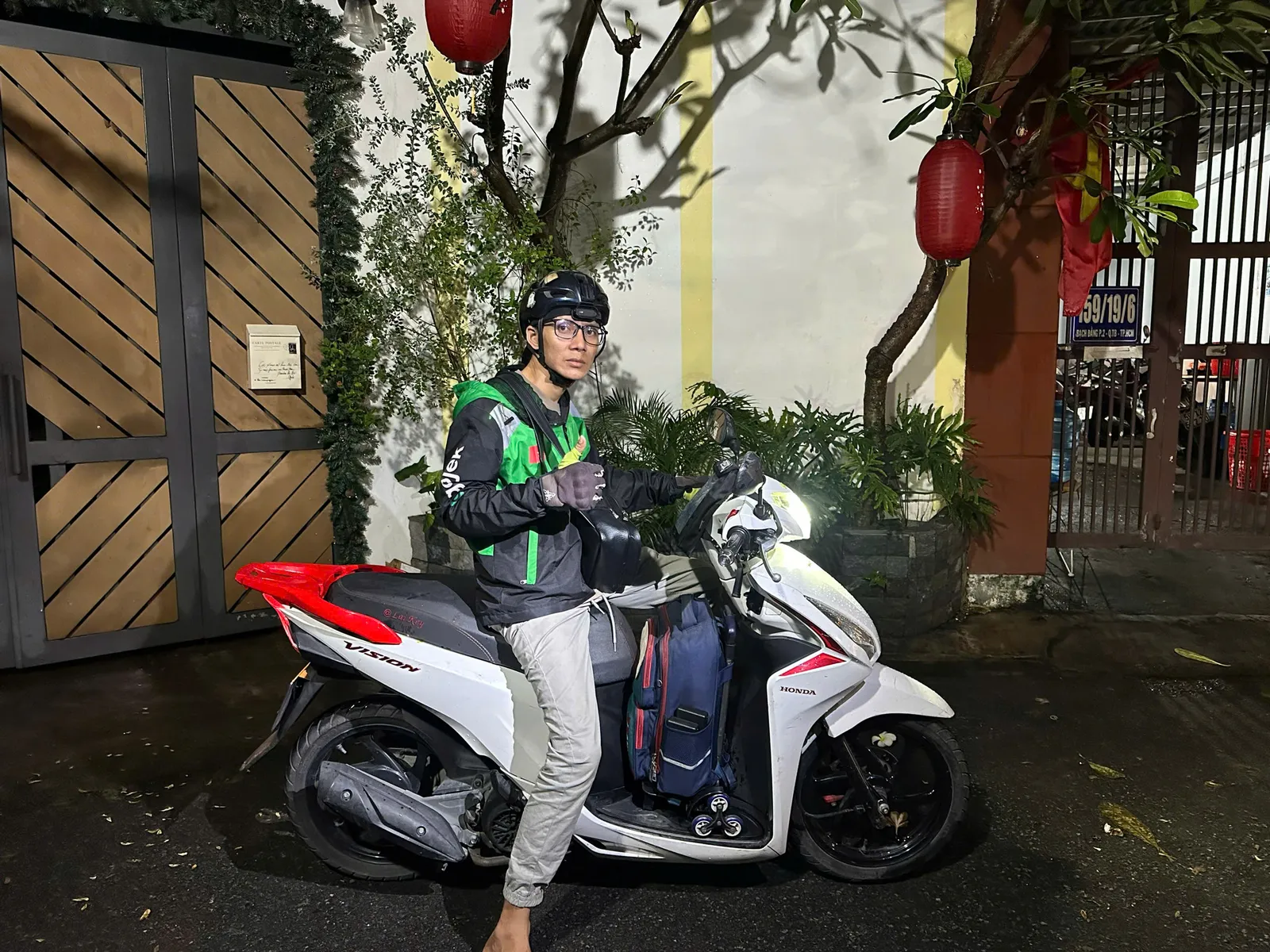 Thợ ngồi trên xe máy, sẵn sàng đến chỗ khách buổi tối
