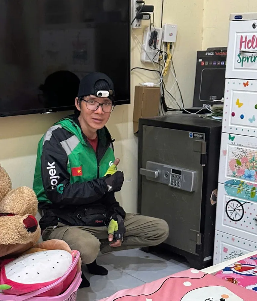 Thợ ngồi bên két sắt điện tử trong phòng khách nhà khách