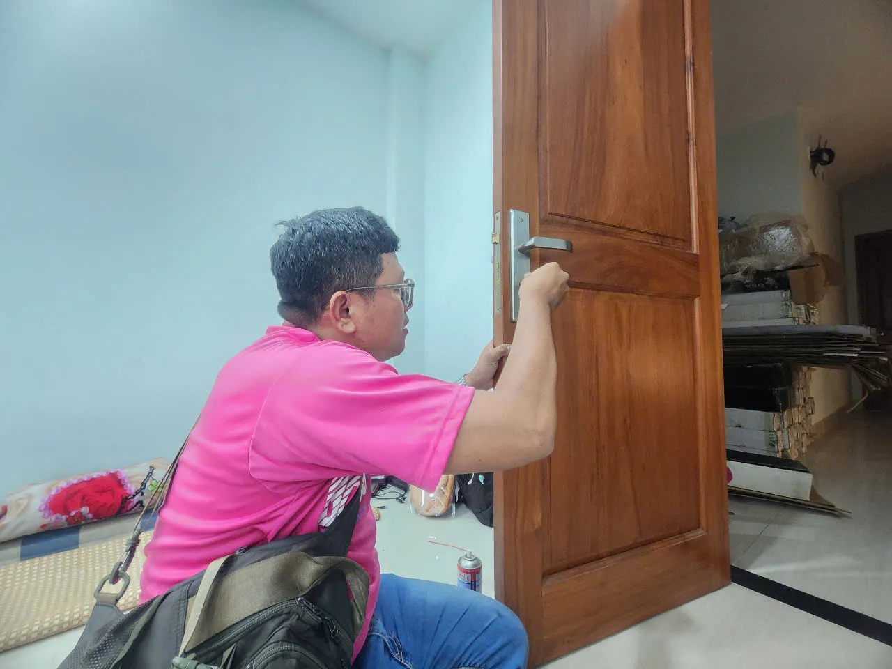 Thợ sửa khóa tay gạt cửa gỗ trong nhà khách