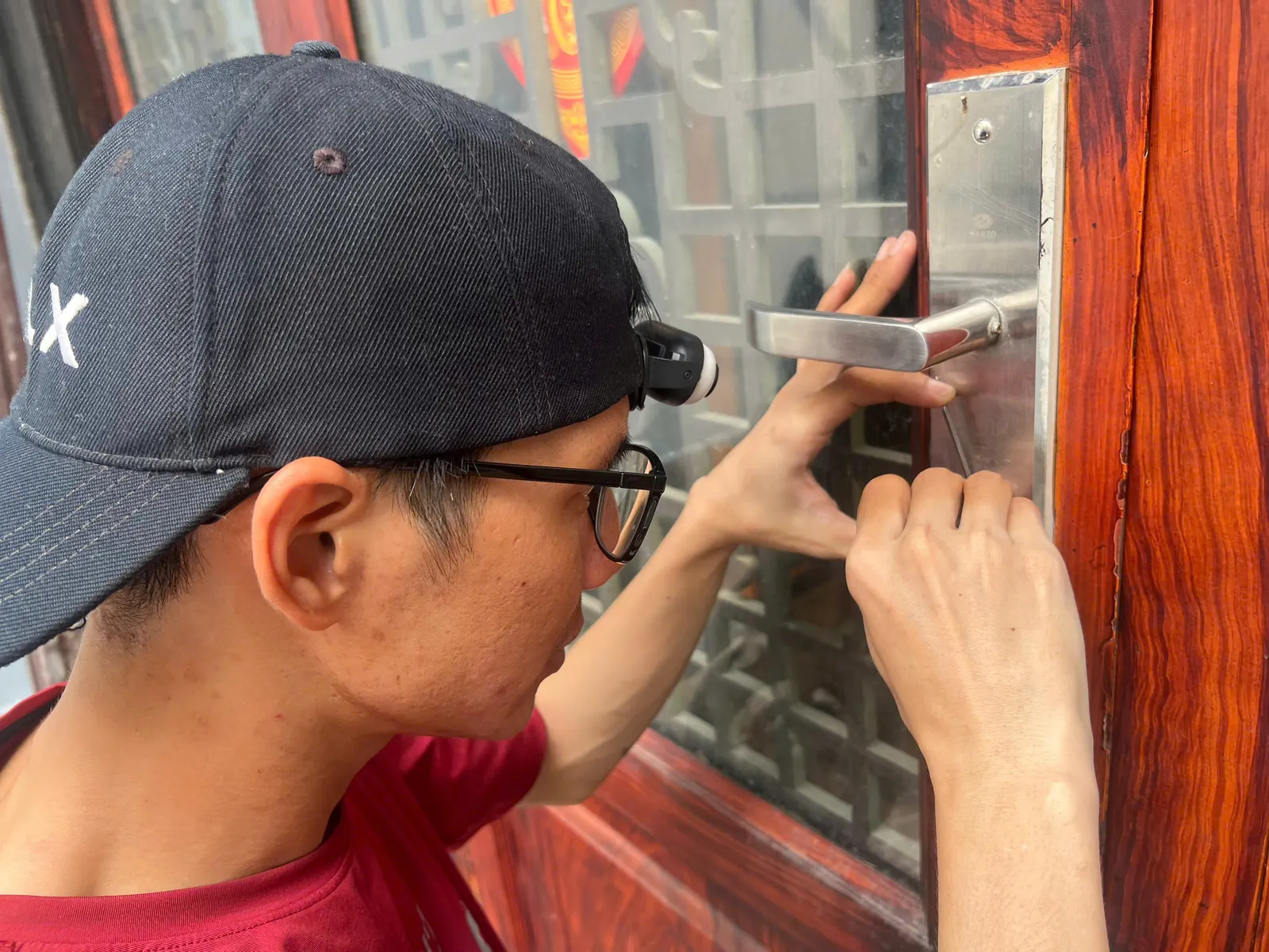 Cận cảnh thợ tháo khóa tay gạt cửa gỗ